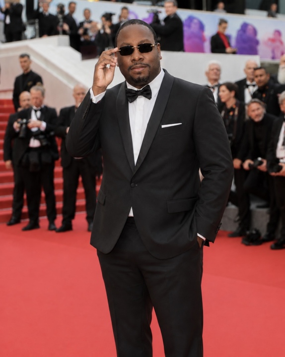 Jon Gosier adjusting his sunglasses on the Cannes red carpet in 2026