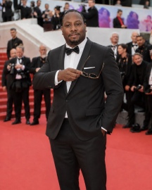 Jon Gosier holding sunglasses on the Cannes red carpet in 2026
