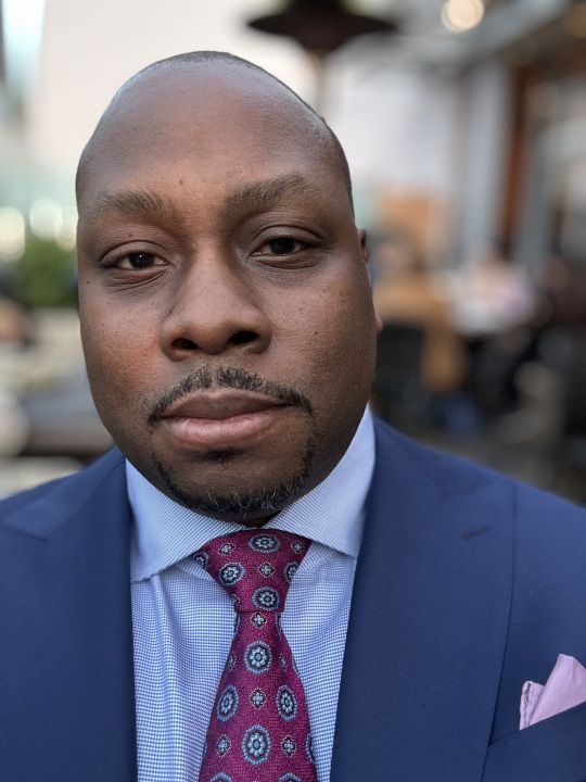 Close-up portrait of Jon Gosier in a blue suit