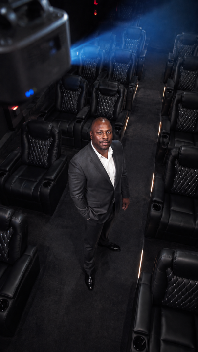Jon Gosier beneath a cinema projector beam