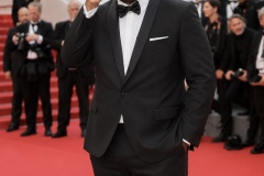Jon Gosier adjusting his sunglasses on the Cannes red carpet in 2026