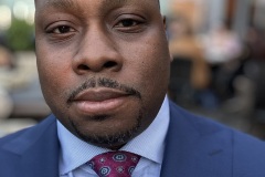 Close-up portrait of Jon Gosier in a blue suit
